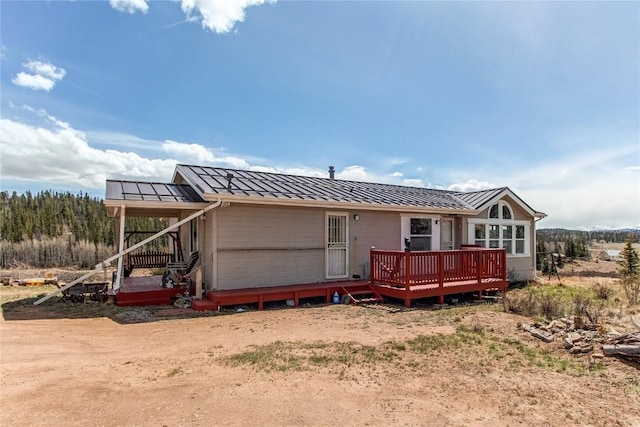 rear view of house featuring a wooden deck