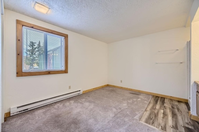 unfurnished room with baseboard heating, light carpet, and a textured ceiling