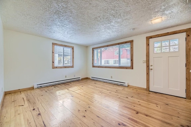 entryway with a textured ceiling, baseboard heating, and light hardwood / wood-style floors