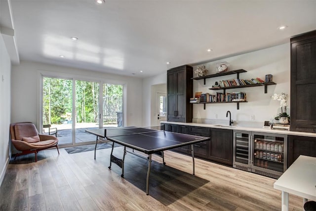 recreation room featuring light wood-type flooring, wine cooler, and wet bar