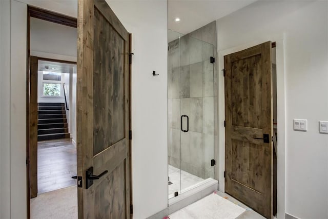 bathroom featuring a shower with door