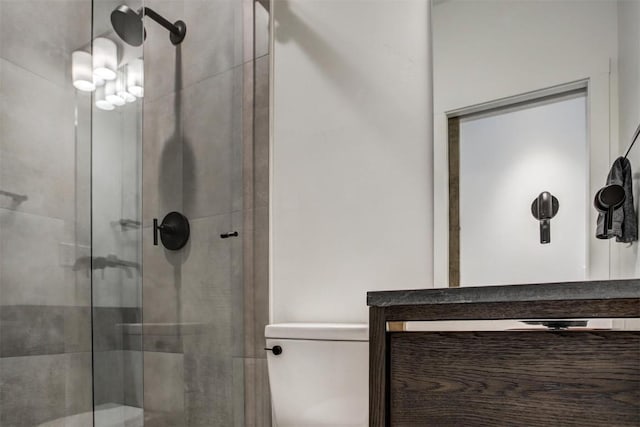 bathroom featuring a shower with shower door and toilet