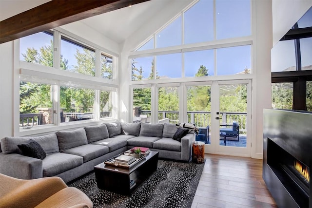 sunroom / solarium featuring lofted ceiling with beams and a healthy amount of sunlight