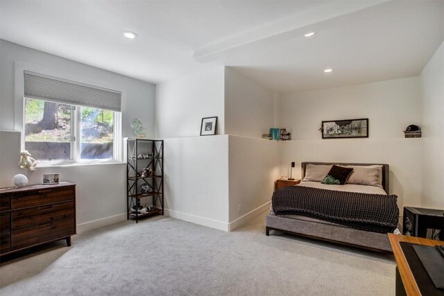 carpeted bedroom with beamed ceiling