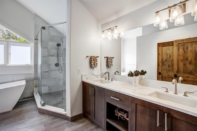 bathroom with vanity, separate shower and tub, wood-type flooring, and vaulted ceiling