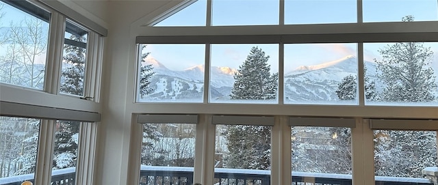 unfurnished sunroom featuring a wealth of natural light and a mountain view