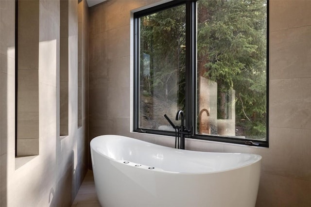 bathroom featuring a tub and tile walls