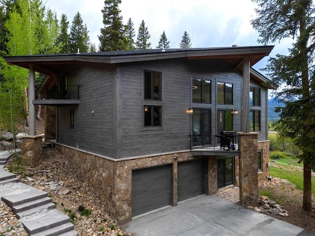 back of house with a balcony and a garage