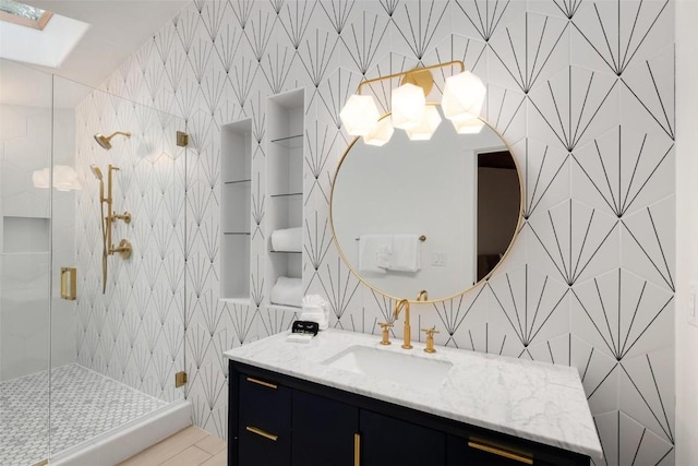 bathroom with a skylight, vanity, and an enclosed shower