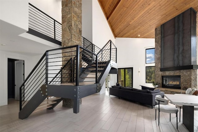 stairway with a fireplace, wood ceiling, and a high ceiling