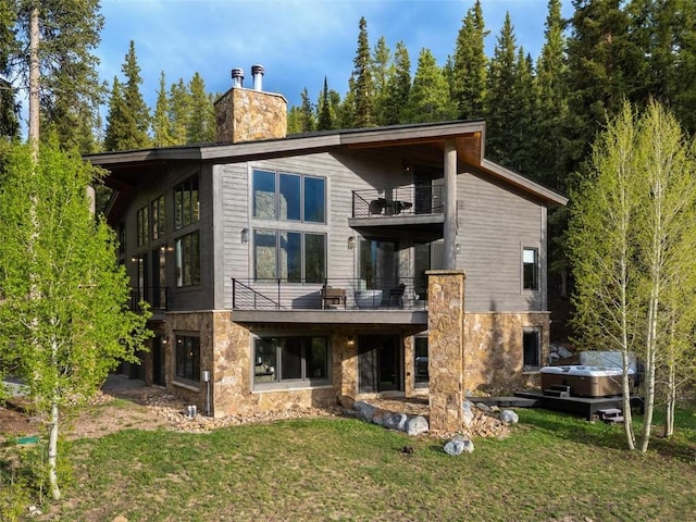 rear view of house featuring a yard and a balcony