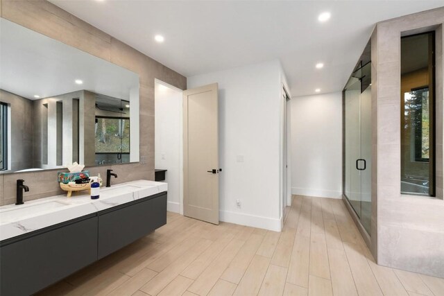 bathroom featuring a shower with door, vanity, and hardwood / wood-style flooring