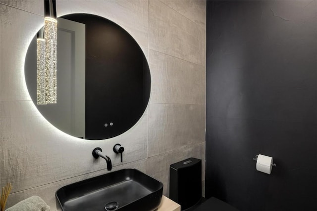 bathroom with sink and tile walls