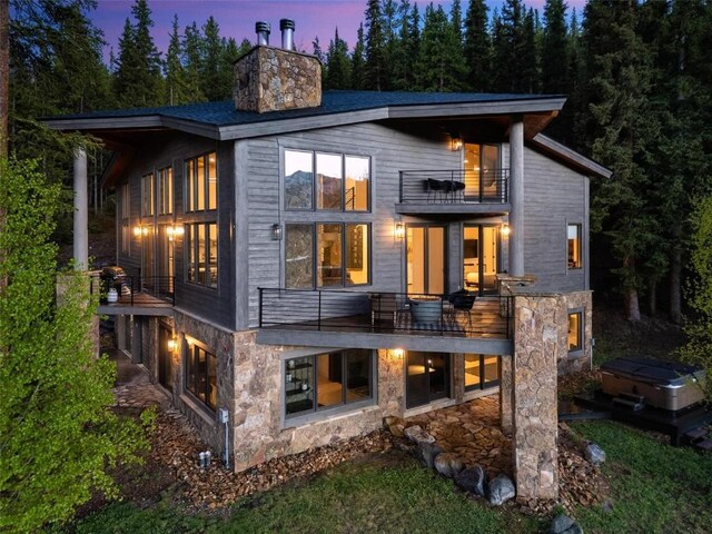 back house at dusk with a balcony