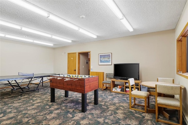 recreation room featuring a textured ceiling and carpet flooring