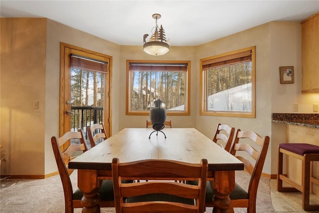 dining room with light colored carpet and baseboards