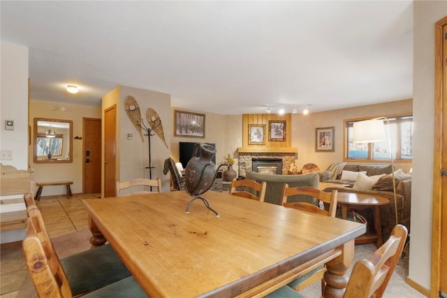 dining area featuring a stone fireplace and track lighting