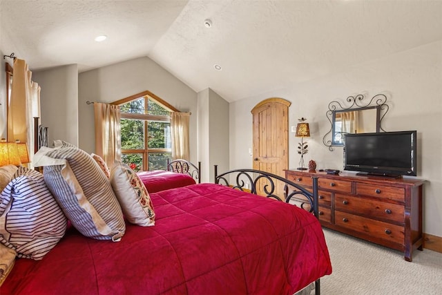 bedroom with a textured ceiling, lofted ceiling, and light carpet