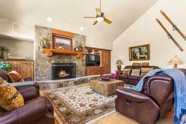 living area with visible vents, ceiling fan, a fireplace, wood finished floors, and high vaulted ceiling