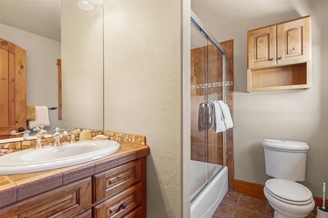 full bathroom featuring tile patterned flooring, toilet, vanity, and bath / shower combo with glass door