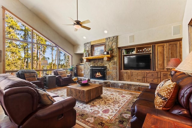 living area featuring a stone fireplace, visible vents, a ceiling fan, and vaulted ceiling