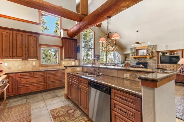 kitchen featuring backsplash, open floor plan, appliances with stainless steel finishes, a fireplace, and a sink