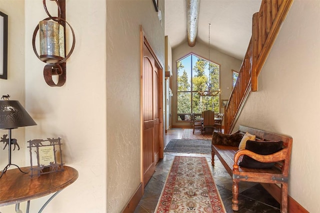 hallway featuring baseboards, high vaulted ceiling, stairs, beamed ceiling, and a textured wall