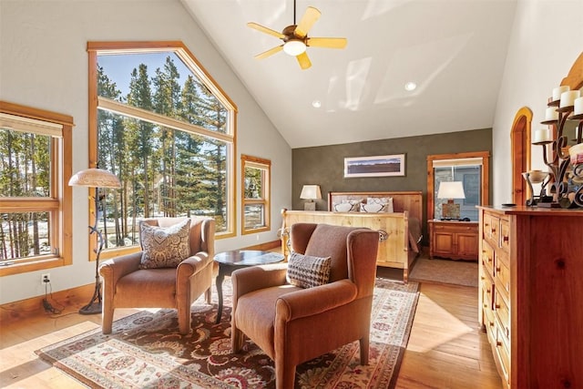 bedroom with baseboards, multiple windows, light wood-style floors, and high vaulted ceiling