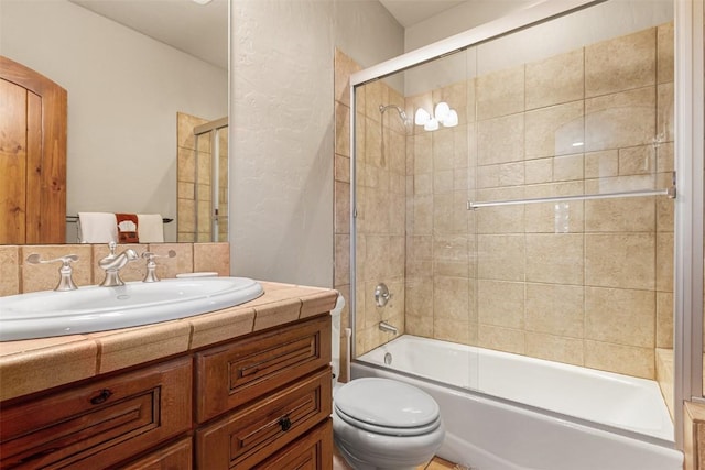 full bathroom featuring enclosed tub / shower combo, toilet, and vanity