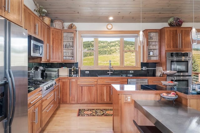 kitchen with sink, hanging light fixtures, light hardwood / wood-style floors, wood ceiling, and stainless steel appliances