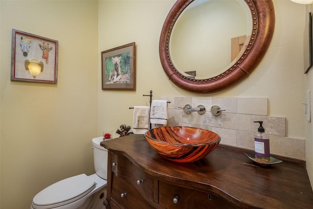 bathroom featuring decorative backsplash, toilet, and vanity