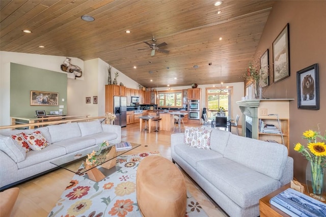 living room featuring light hardwood / wood-style floors, vaulted ceiling, ceiling fan, and wooden ceiling