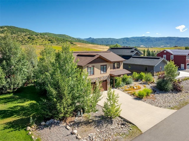 view of front facade with a mountain view, a garage, and a front lawn