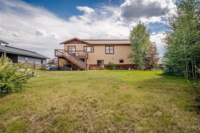 rear view of house featuring a lawn and a wooden deck