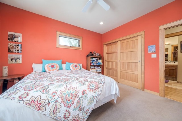 bedroom with ceiling fan, sink, carpet, and ensuite bathroom