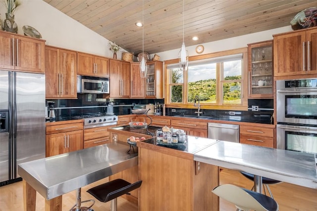 kitchen featuring a kitchen breakfast bar, sink, wood ceiling, and stainless steel appliances