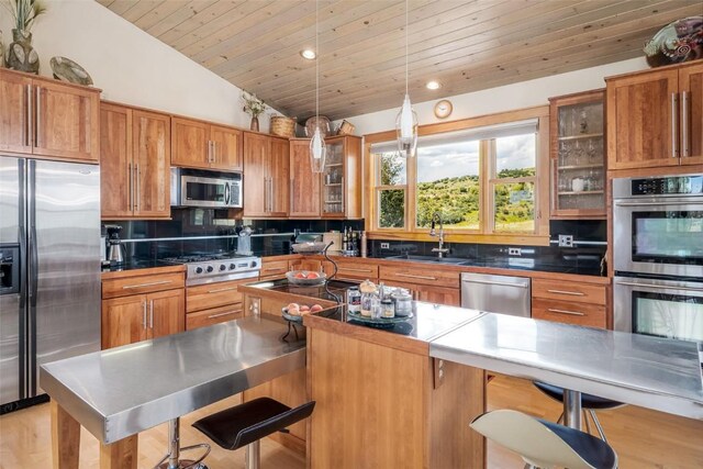 kitchen with appliances with stainless steel finishes, backsplash, lofted ceiling, and sink