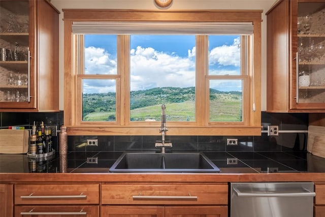 kitchen with a mountain view, stainless steel dishwasher, a wealth of natural light, and sink