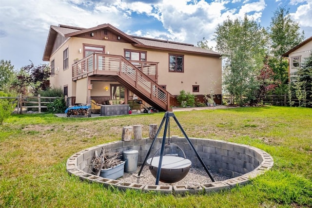 back of property featuring a lawn and a wooden deck