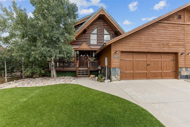 log cabin featuring a front yard, a deck, and a garage