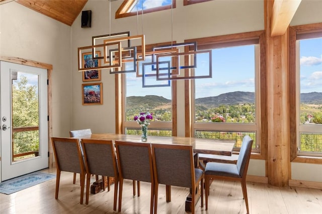 dining room featuring vaulted ceiling, a mountain view, and plenty of natural light