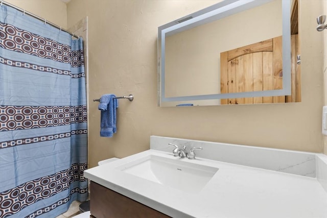 bathroom featuring walk in shower and vanity