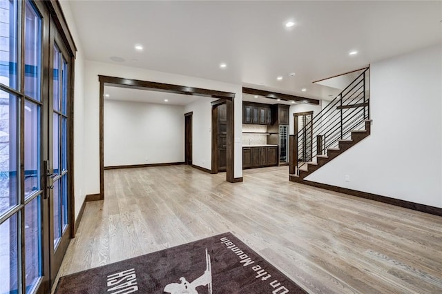 unfurnished living room with light hardwood / wood-style flooring and french doors