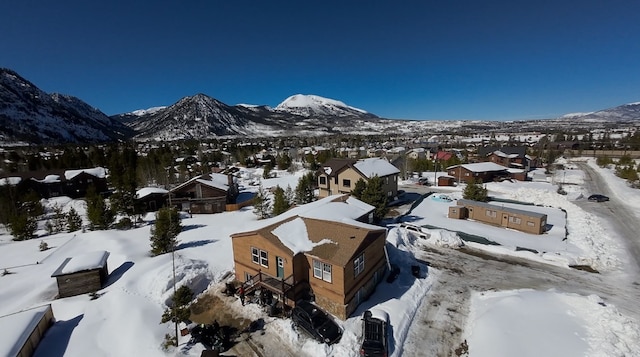 snowy aerial view featuring a residential view and a mountain view