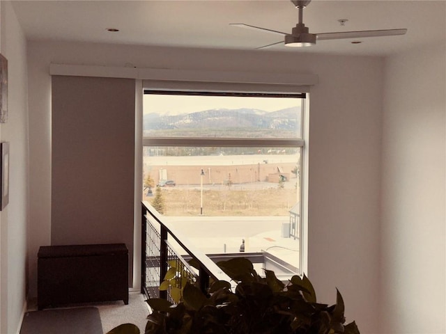 interior space with ceiling fan, carpet, and a mountain view