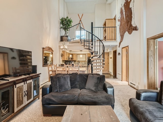 living room with a towering ceiling, stairway, light carpet, and a baseboard heating unit