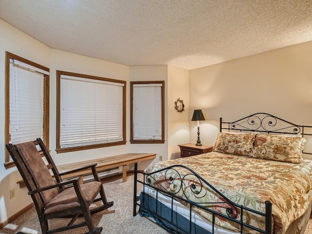 carpeted bedroom featuring a textured ceiling and baseboards