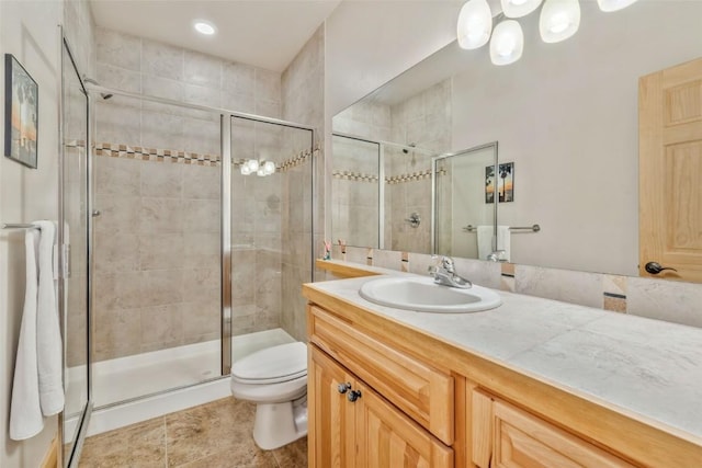 bathroom featuring a stall shower, toilet, and vanity