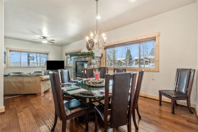 dining space with baseboards, a healthy amount of sunlight, hardwood / wood-style floors, and ceiling fan with notable chandelier