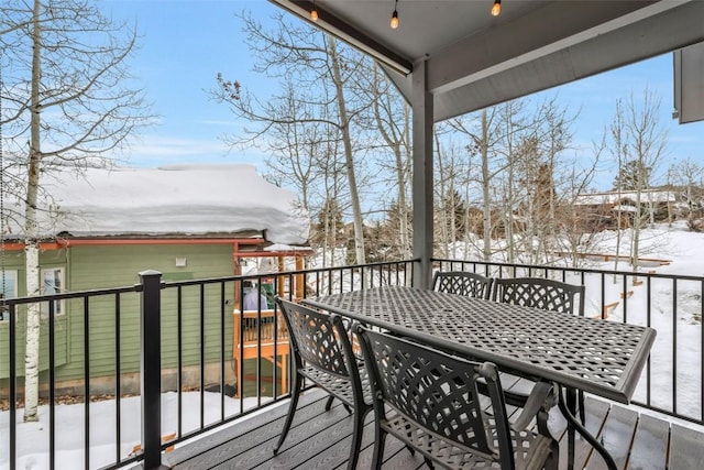 snow covered deck with outdoor dining space